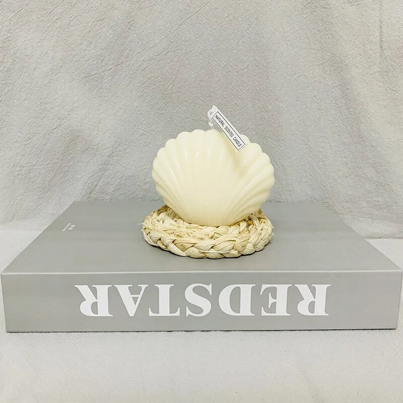 Shell candle home decoration on a woven base, perfect for coastal home decor and gifting.