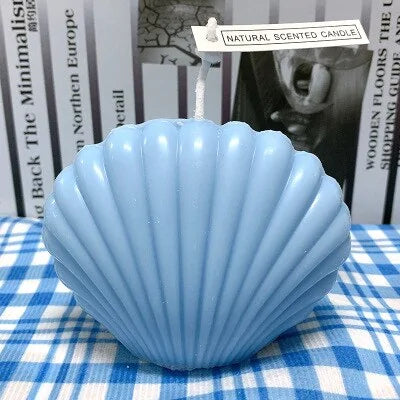 Blue shell candle home decoration on a checkered tablecloth with a natural scent tag.