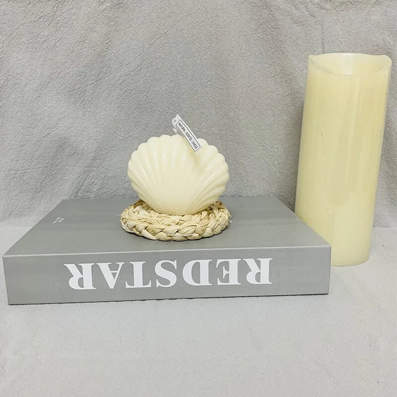 shell candle home decoration placed on a book with a pillar candle, creating a coastal charm ambiance.