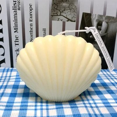 shell candle home decoration made of wax in a delicate shell shape on a plaid tablecloth.