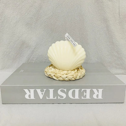 Shell candle home decoration on a woven base, perfect for coastal home decor and gifting.